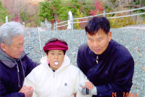 Julia Kim in ecstasy miraculously receives the Most Holy Body, supported by two faithful